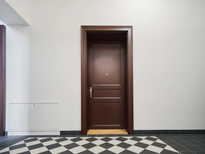 Interiérové dveře Internal Door, bytový dům Svornosti – dveře v bílé chodbě se šachovnicovou podlahou