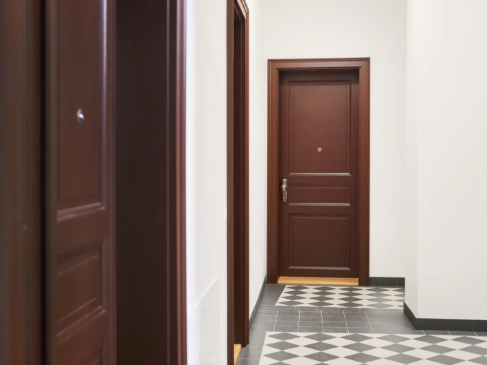Interiérové dveře Internal Door, bytový dům Svornosti – dveře na konci chodby se šachovnicovou podlahou