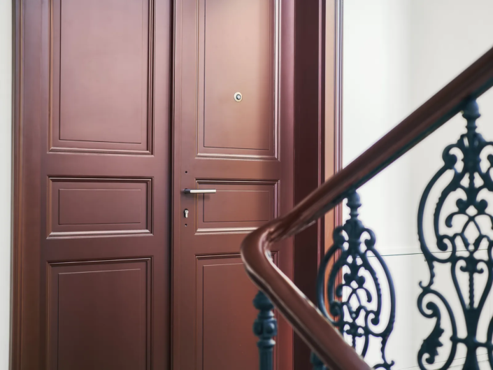 Interiérové dveře Internal Door, bytový dům Svornosti – detail kazetových dveří a litinového zábradlí